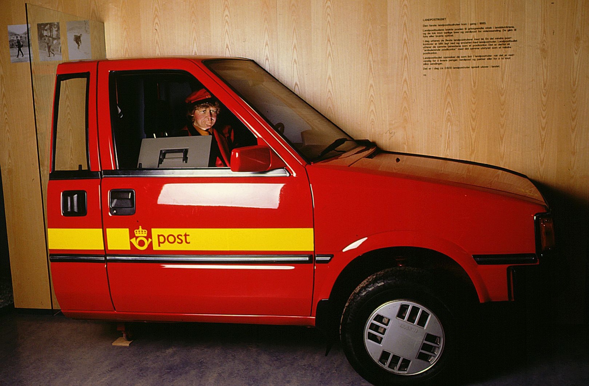 postmuseet, Kirkegata 20, utstilling, landpostbud med rød postuniform i postbil på vei ut med post