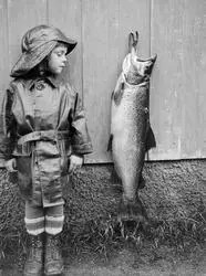 Liten gutt med fisk. gunnar med den store fisken.