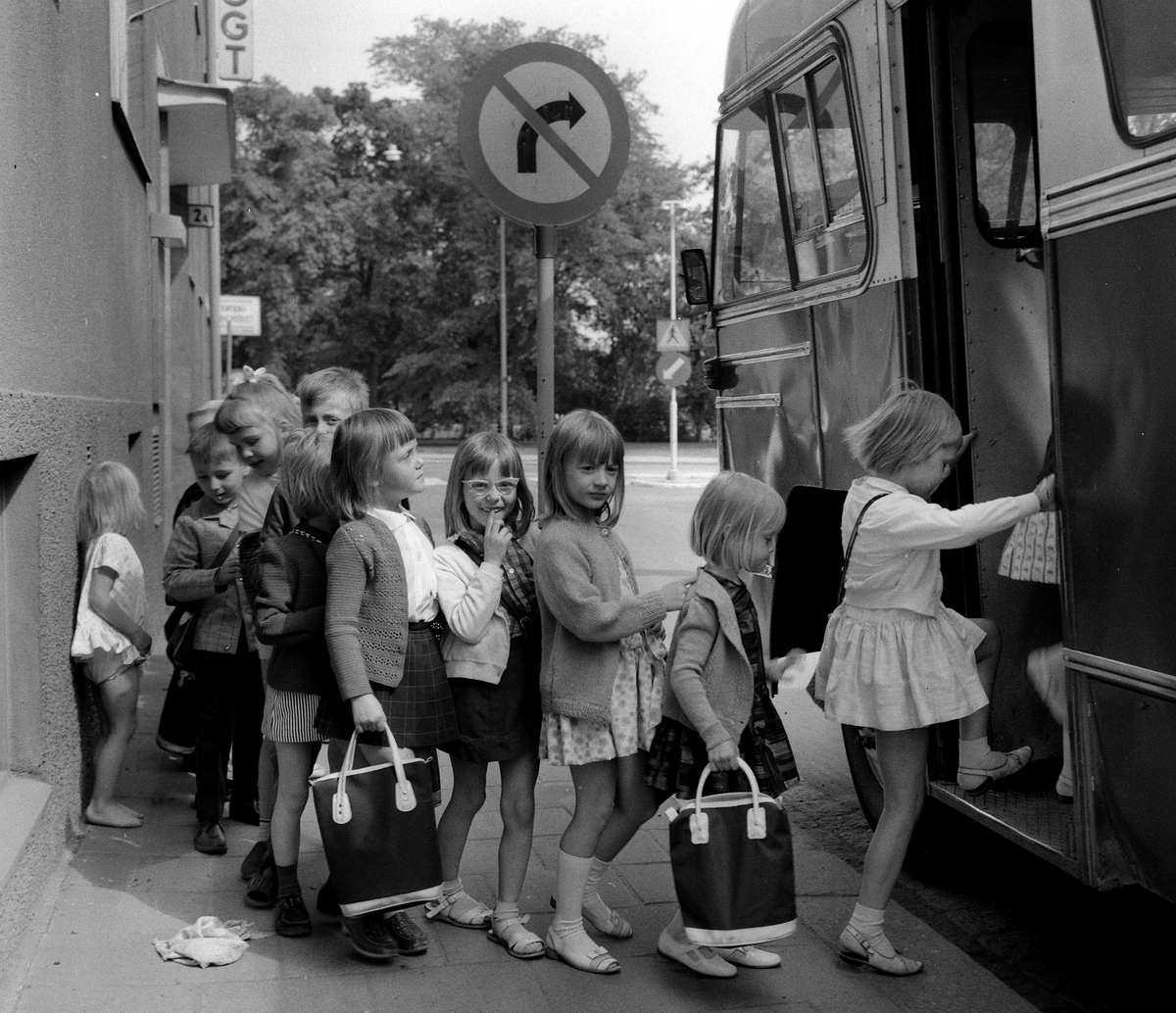 Småskolebarn på väg ut på skolresa, bussen står vid Snickaregatan.  1967