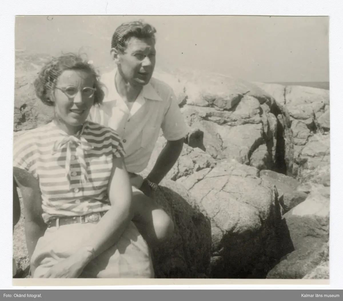 Signild Franzén och Tore Johansson sittande på en klippa vid havet. Troligtvis taget tidigt 1940-tal. Påskrift baksida: Signild Franzén Tore Johansson.