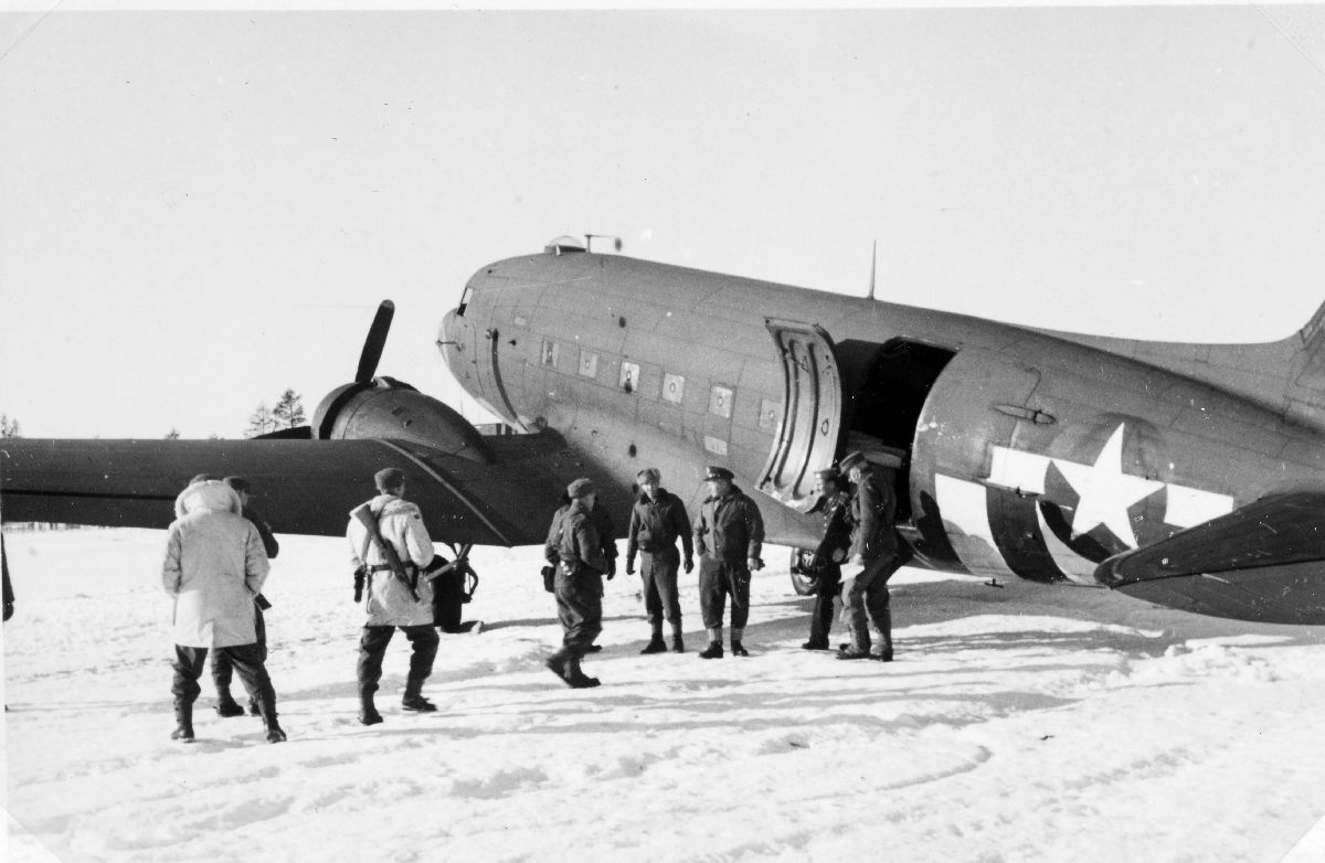 Balchen med mannskap sammen med to medlemmer fra de norske polititroppene foran en Douglas C-47. Antagelig i forbindelse med transport til Finnmark.
