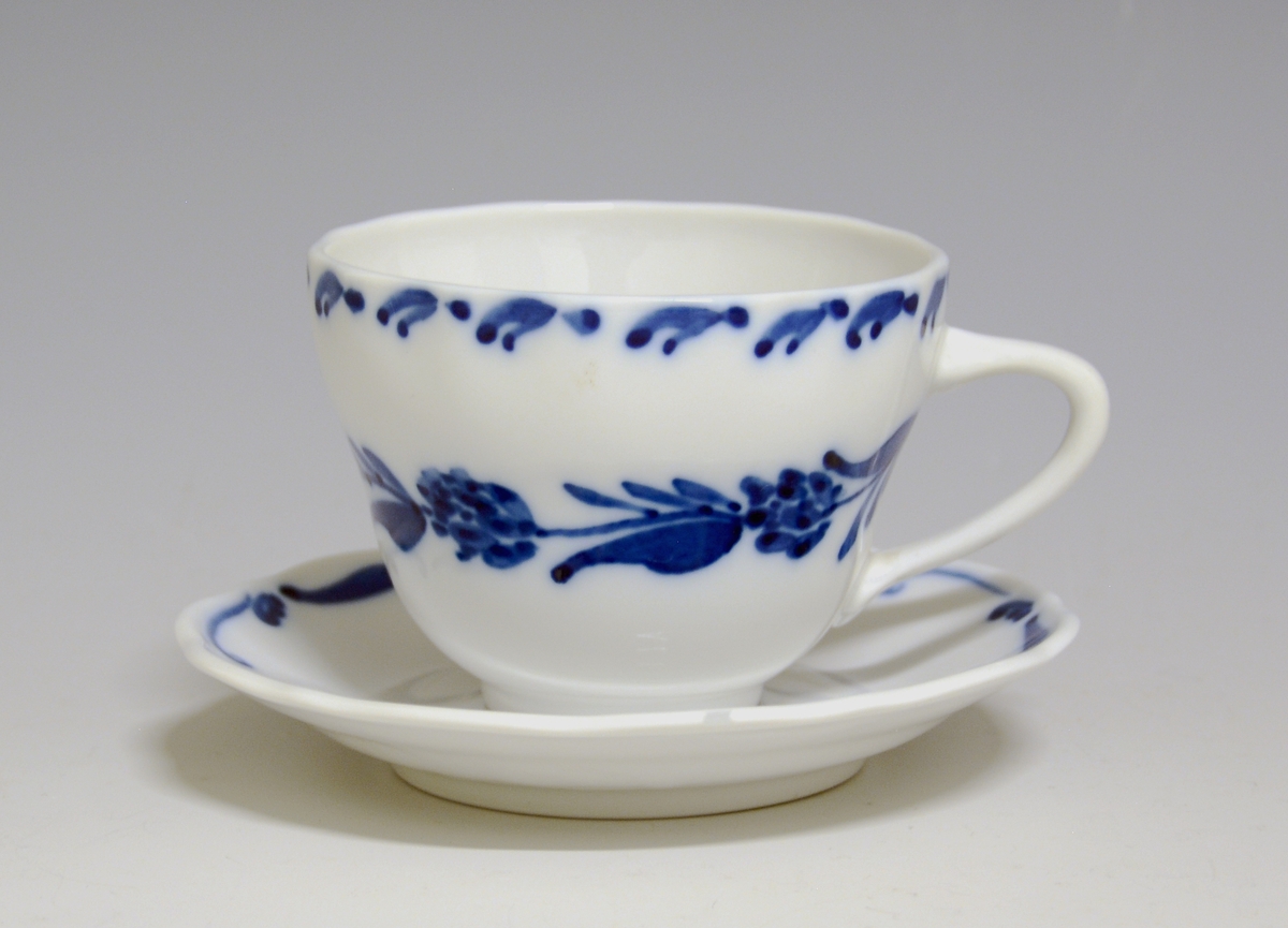 Kaffeskål av porselen. Hvit glasur. Håndmalt blå underglasurdekor på fanen.
Modell: Victoria, 1800
Uten fabrikkmerke.
