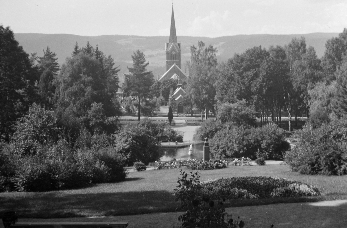 Søndre park i Lillehammer med utsikt mot Lillehammer kirke. I retning mot kirken sees monumentet over Carl Lumholtz (1851-1922) og skulpturen "Leda og svanen".
