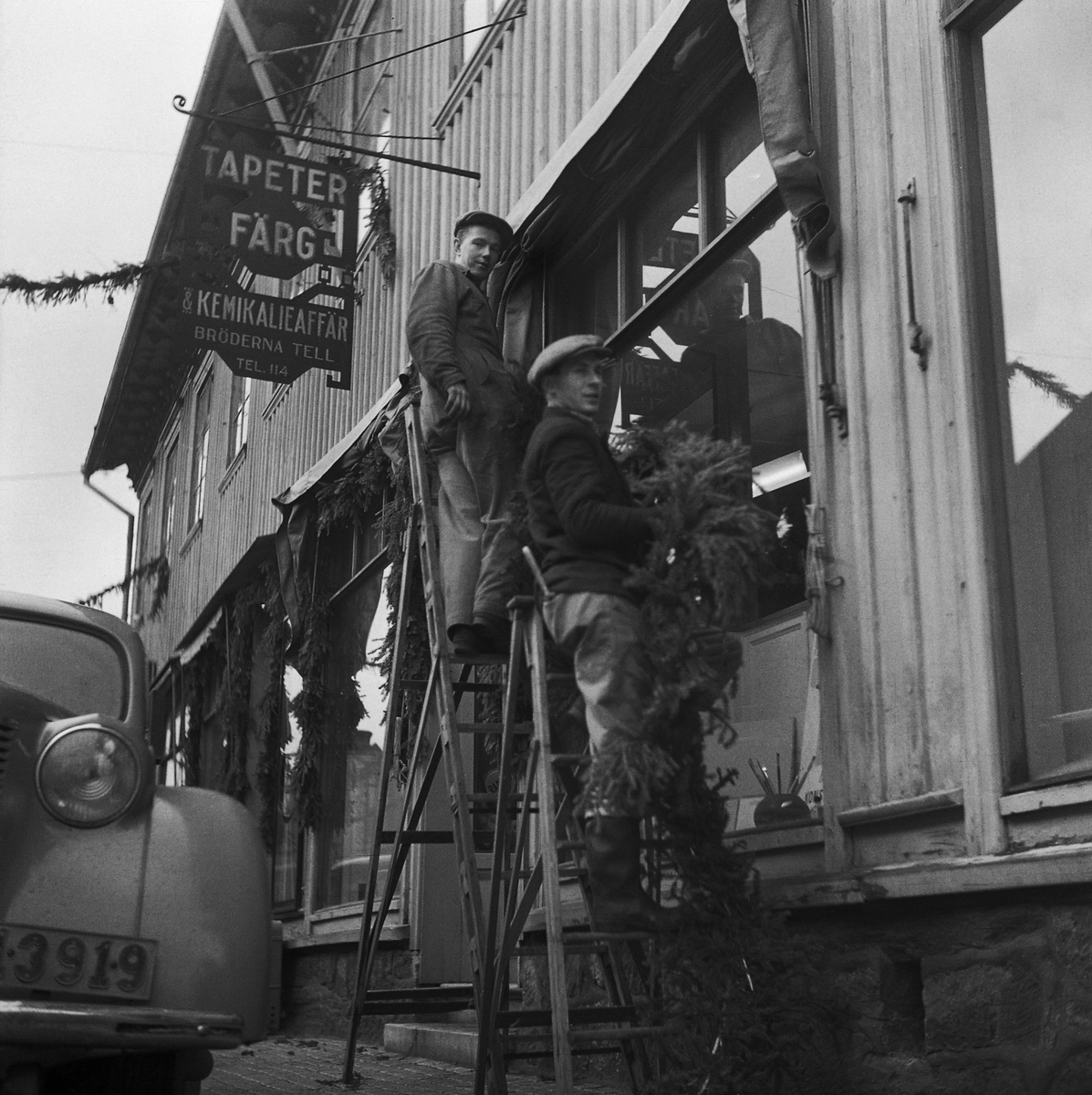 Uppsättning av juldekorationer framför Tells färgaffär på Kungsgatan, Kv Jägaren, 1949.