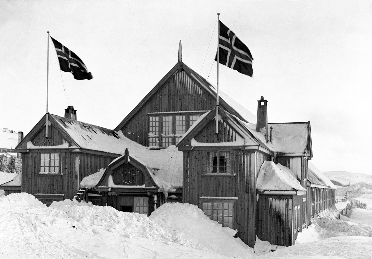 Fasaden på Finse Skøytehall med norske flagg til topps, Finse, Ulvik, Hordaland, 1913.