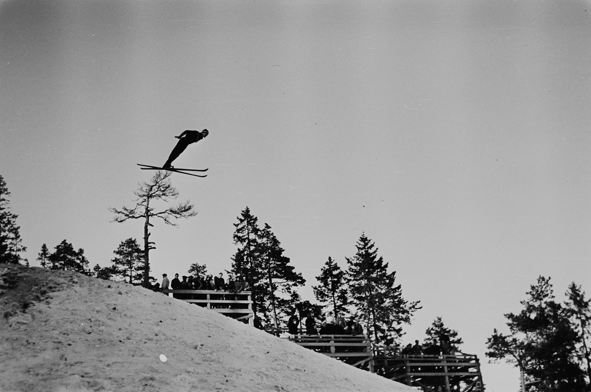 Skihopper i lufta i Holmenkollbakken, Oslo. Fotografert 1940.