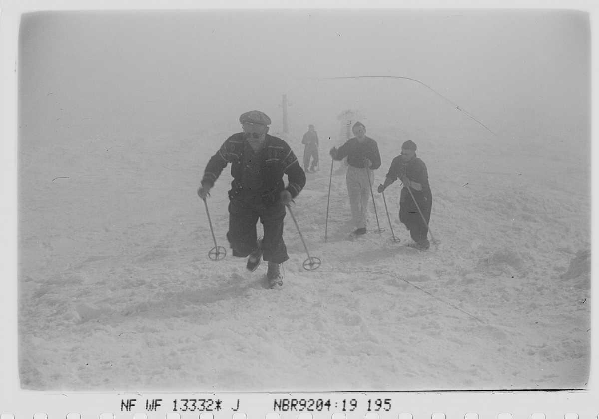 Skigåere med staver uten ski på vei til Gaustahytta i påsken. Fotografert 1940.