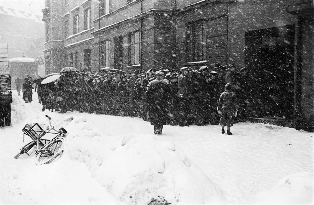 Kø foran vinmonopolets utsalg vinterstid, Fredrik Stangs gate 41, Oslo. 1. mars i 1941.