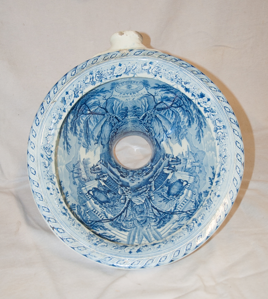 Porslinsklosett med blå koppartryck-blomdekor på överdelen och i skålen blå orientalisk dekor.