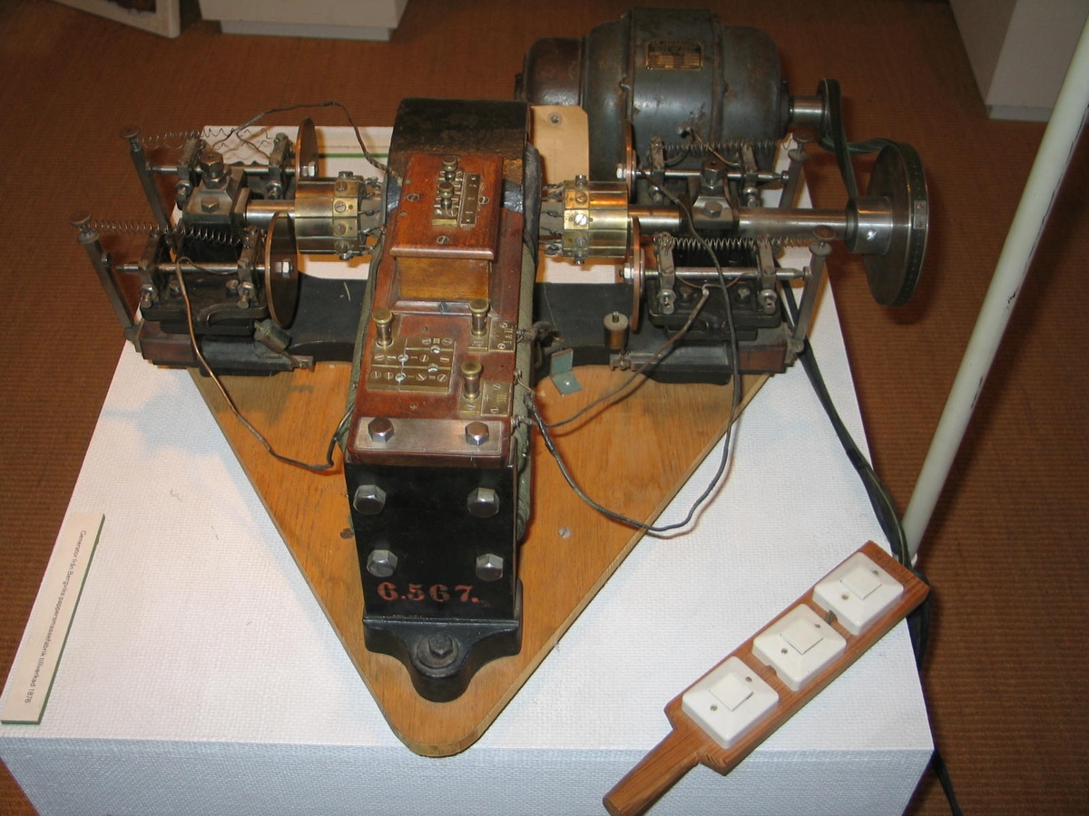 Troligen för galvanisering, provisoriskt fästad på en träplatta. Etsad skylt märkt: "Sigm. Schuckert/ Nürnberg/N:o 24". Fundamentet av gjutjärn, vilket är spräckt. En stoppmutter med refflad kant saknas och  åtta st. nitar fattas. (Motsvarande maskin i Deutsches Museum: 1.200 v/min 4 volt 30 amp.) 40 (?) volt 30 amp. 1200 varv.