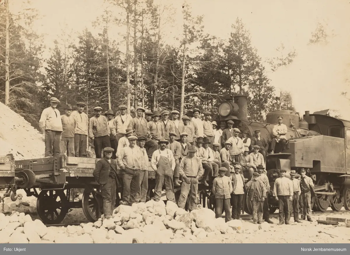 Anleggsarbeidere på Raumabanen. Bak til høyre damplokomotiv type 34a nr. 345
