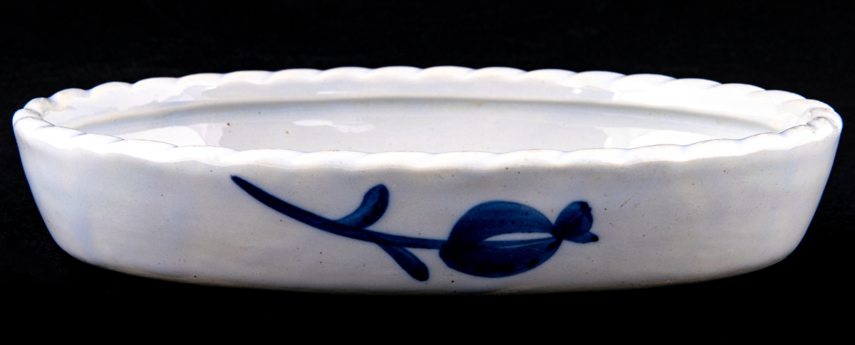 Oval omelettform i flintgods med dekorativ flätad kant, modell B, storlek 2, eldfast (enligt Gefle Porslins priskurant 1931) men kan även användas som pajform. Dekor Blått band.