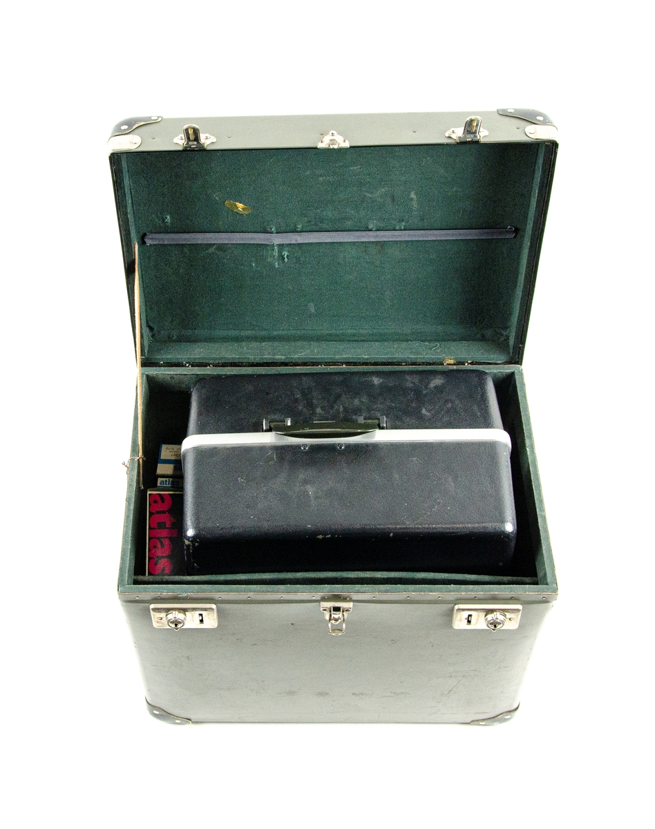Ljudfilmsprojektor, Bell & Howell filmsound. Model 643 SK. Till projektorn hör även en anslutningskabel, två tomma filmrullar samt sex stycken Atlas projektorlampor. Detta är förvarat i en specialanpassad låda av plast. Den gråa lådan är förstärkt i alla hörn med svarta metallhöljen.