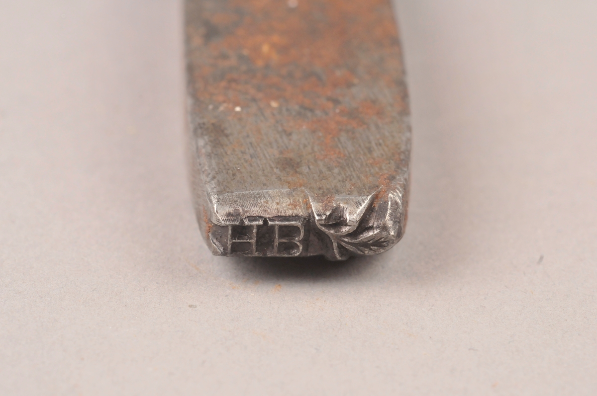 Stempel for metall med initialer.