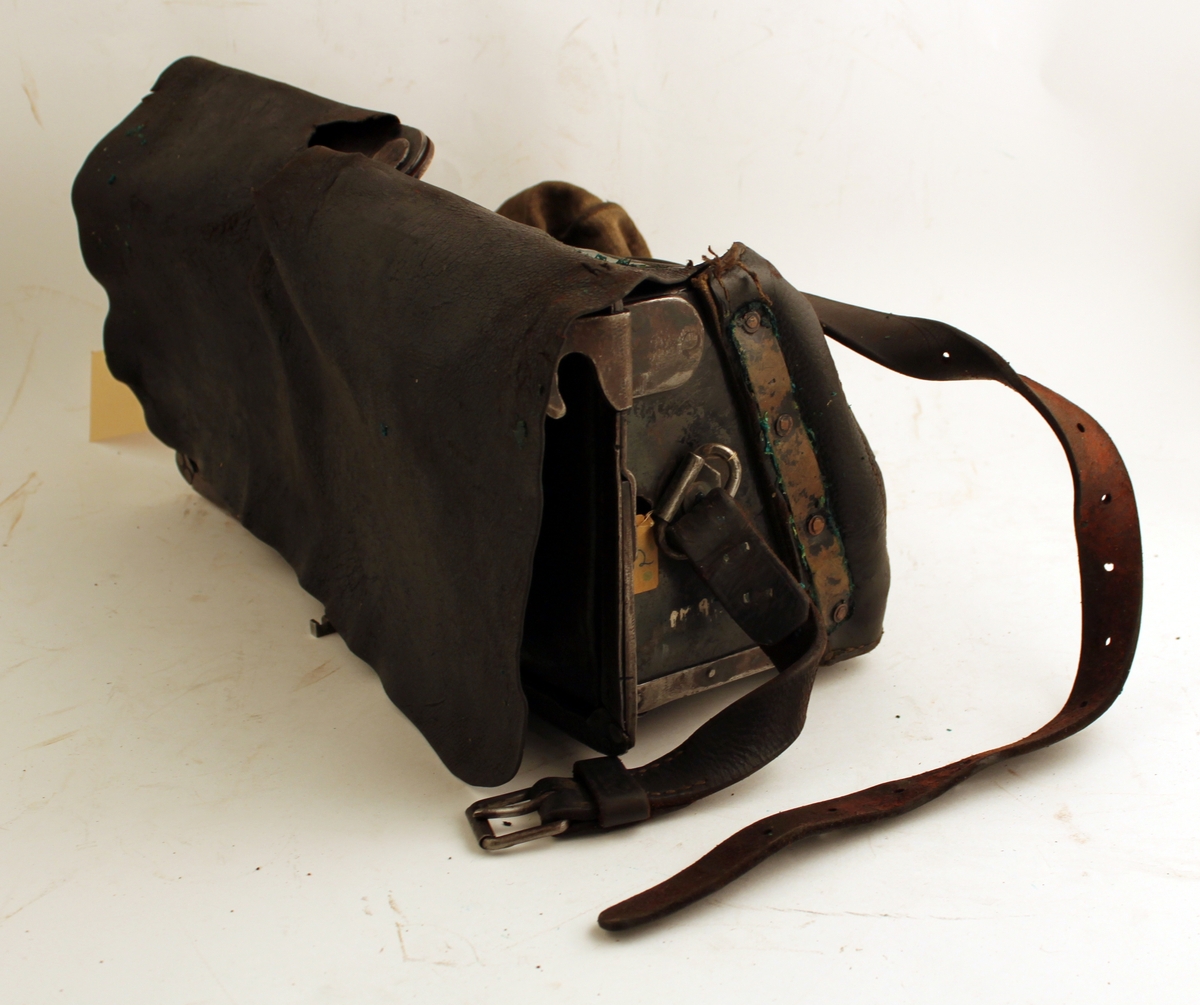 Tömningsväska av svärtat läder och tyg med ram av svartlackerat järn. Med låsram.