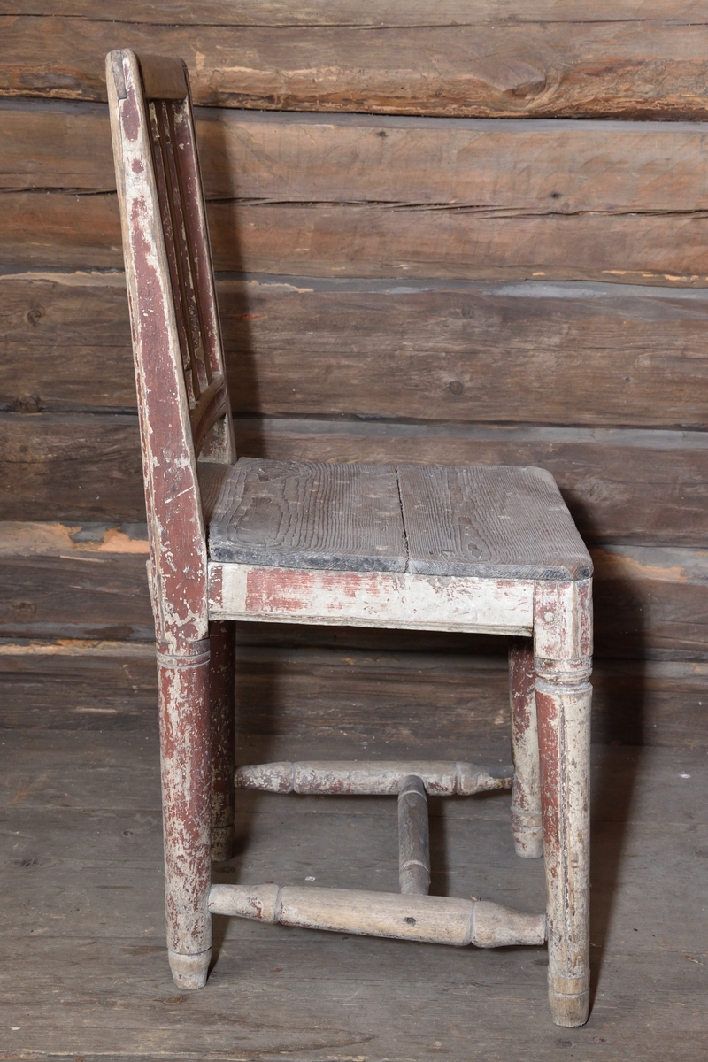 Stol tillverkad i trä. Rektangulär ryggbricka, delvis genombruten med tre spjälor. Enkel ostoppad sits. Stolen står på fyra rundsvarvade ben, ornerade med gles kannelyr. Mellan benen ett svarvat H-format benkryss. Stolen har tidigare varit målad rödbrun. 