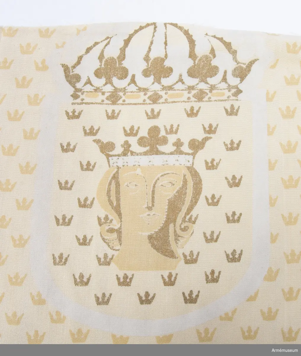 Tygprov från 1940-talet. Tillverkat för Överståthållarämbetet. Formgivet av Astrid Sampe. Textiltryck endast på en sida föreställande såsom botten prinskronor regelbundet formade över ytan i guld och gult. Utsparade motiv av Stockholms vapenbild på en sköld och krönt med en kunglig krona. Just det utsparade motivet verkar tunt i trycket.