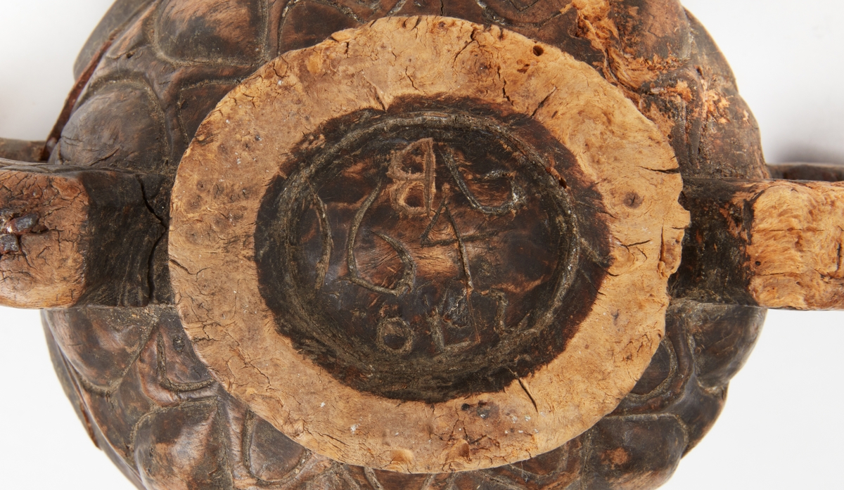 Kåsa från Orsa. Av trä med skuren dekor. Två handtag i drakhuvudliknande form. Under skuret: "1646, OLS, B"