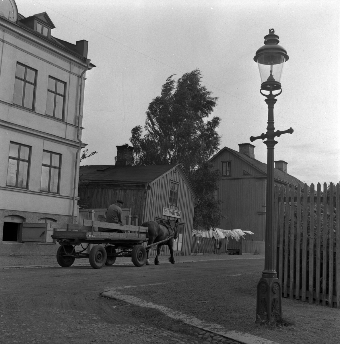 En man kör häst och vagn förbi "June Tvätten", Jönköping.