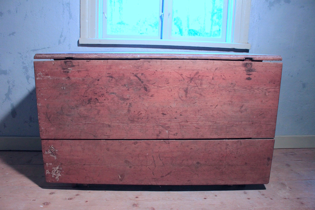 Slagbord av trä med profilerad sarg. Svängda ben. En skiva som går att fälla upp. Låda på ena kortsidan. Målad röd. Avskavd. Skivan ranglig, glipar men sitter fast med slår undertill. 