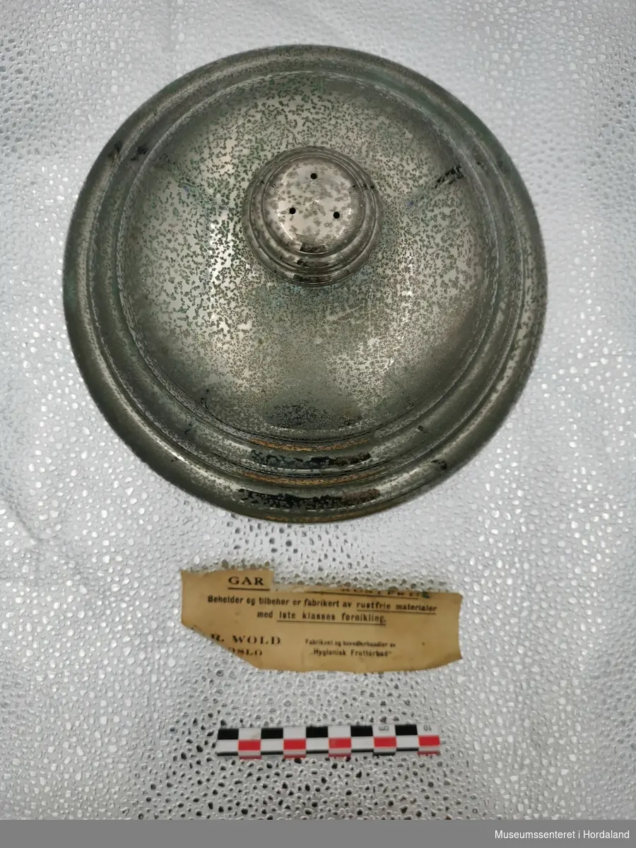 Form: høg sylinder med rundt lok med knott, Gummislange, dusjhove og metallring
