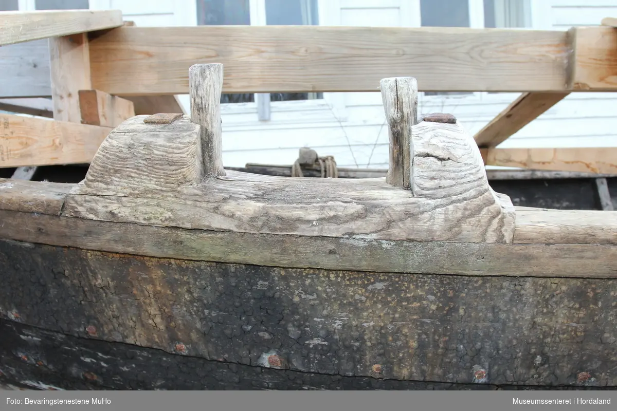 Klinkbygget storebåt med 7 bord og rester av 2 par årepinner. Det er en kraftig bygget føringsbåt med høyt fribord. På ripa til den ene stevnen står et fastspikret hjul.