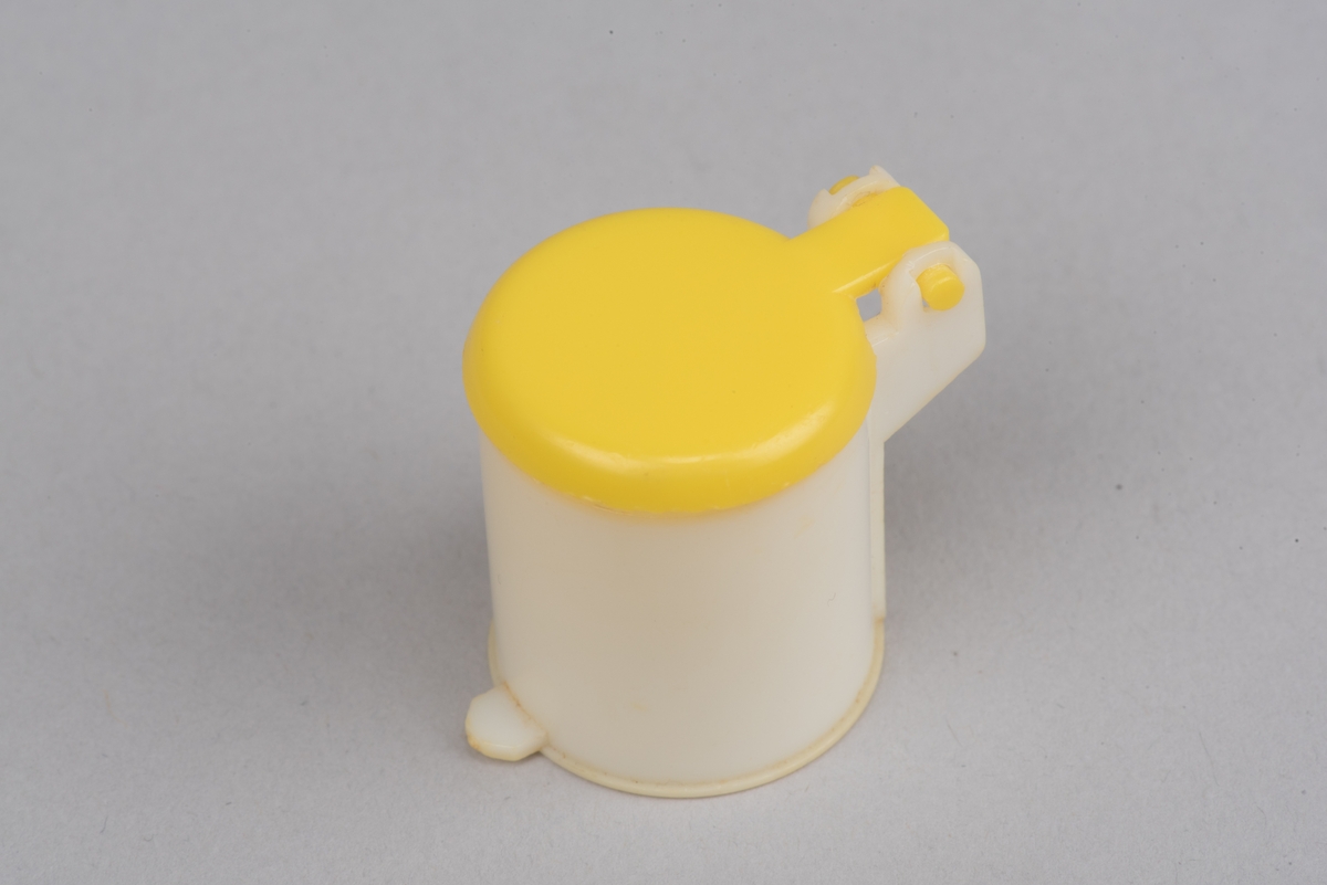 Dokskåpsinredning i form av en pedalhink av plast. Locket går att öppna.
Cylinderformad hink i vit plast med pedal och öppningsbart gult lock.