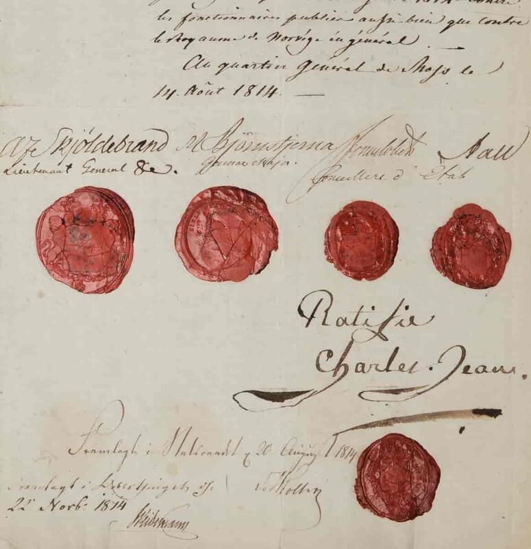 Nærbilde av Mossetraktaten. Et litt flekkete papir med sirlig, gammeldags håndskrift, signaturer og preget med fem røde lakk-segl.