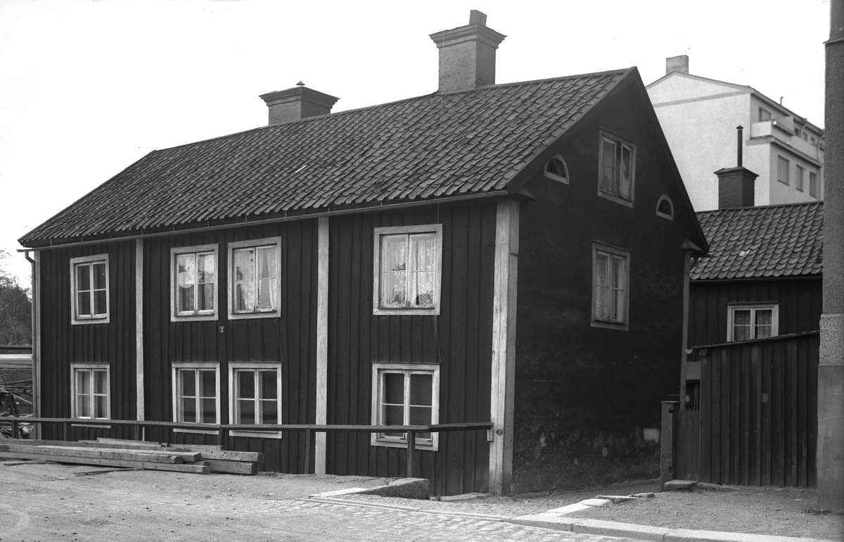 I hörnet av Ågatan-Hamngatan i Linköping stod ännu i slutet av 1930-talet dessa bägge trähus kvar invid framryckande och moderna höghus av sten och betong. Närmast Ågatan 2 framför det skymda Hamngatan 16.