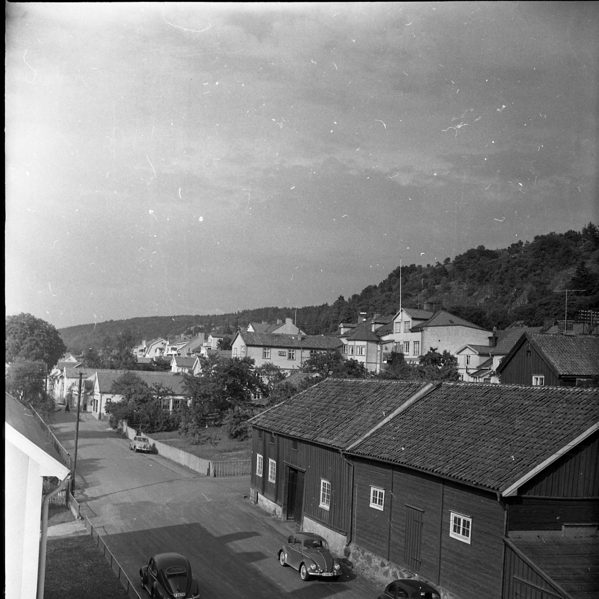 Utsikt över sjögatan i Gränna. Längst med gatan står bilar. I bakgrunden syns Grännaberget.