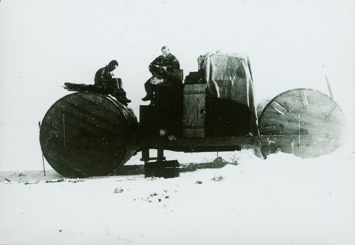 Fotografi från expedition till Spetsbergen. Motiv av man och kvinna som sitter på ett slags fordon.