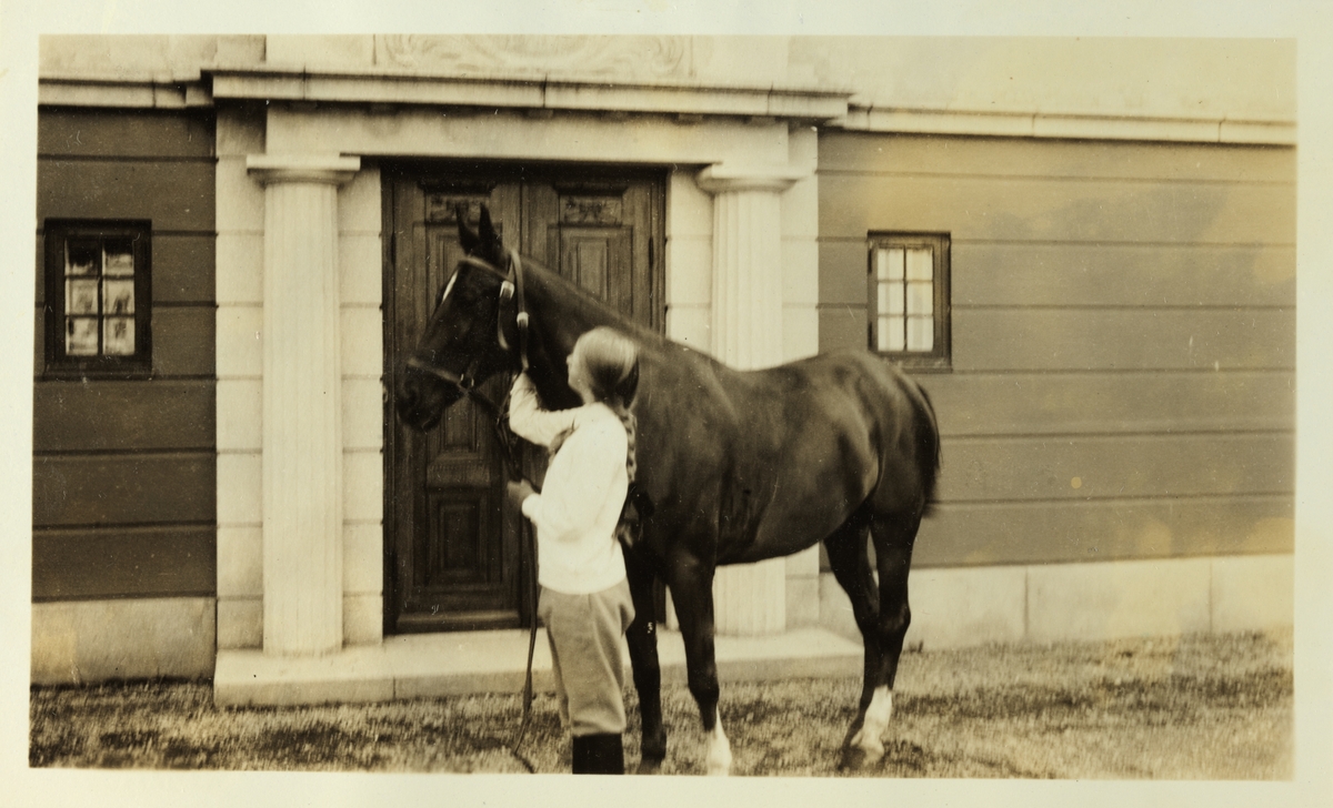 Karen Egeberg med ridehesten "Fox" foran inngangspartiet på Bogstad gård. Fotografert august 1926.