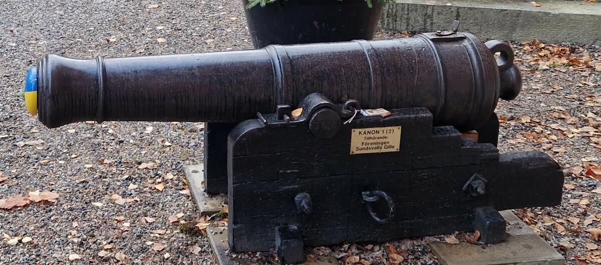 Kanon med mässingsskylt: "Kanon 1 ( 2 ). Tillhörande: föreningen Sundsvalls Gille." Blå/gul träplugg i kanonröret. Kanonen står skyddat på fyra betongplattor 35 x 35 cm:s med plåtbit + najtråd. En engelsk fartygskanon i gjutjärn, tillverkade av Baely Pegg & Company omkring år 1800. Kaliber 10 cm. Enkel trälavett. Kanonen är märkt B PoC och nr 830. Sundsvalls Gille erhöll den (tillsammans med MFF15233) som gåva av Sundsvalls hamn 1953. Meningen var att kanonerna skulle ställas som ett monument intill Widesbron riktade mot varandra, till minne av det ryska anfallet på Sundsvall 25 maj 1721. Av okänd anledning blev inte detta utfört och de placerades på Norra stadsberget och sedan framför den gamla Vinfabriken där de stod under många år. 