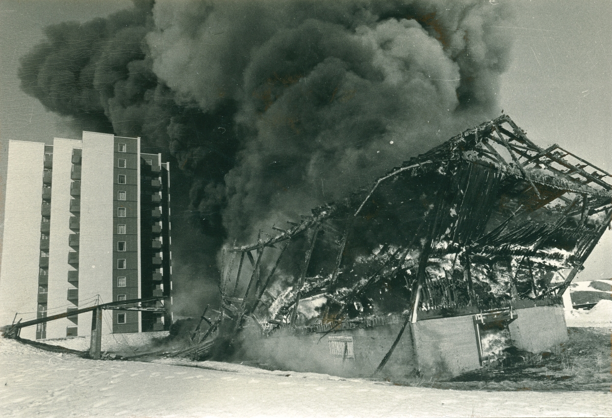 Tre bilder som viser en brann i noe som kan ligne en låve e.l. i nørheten av boligblokker. Bygningen er totalskadd. Snø. Røyk.