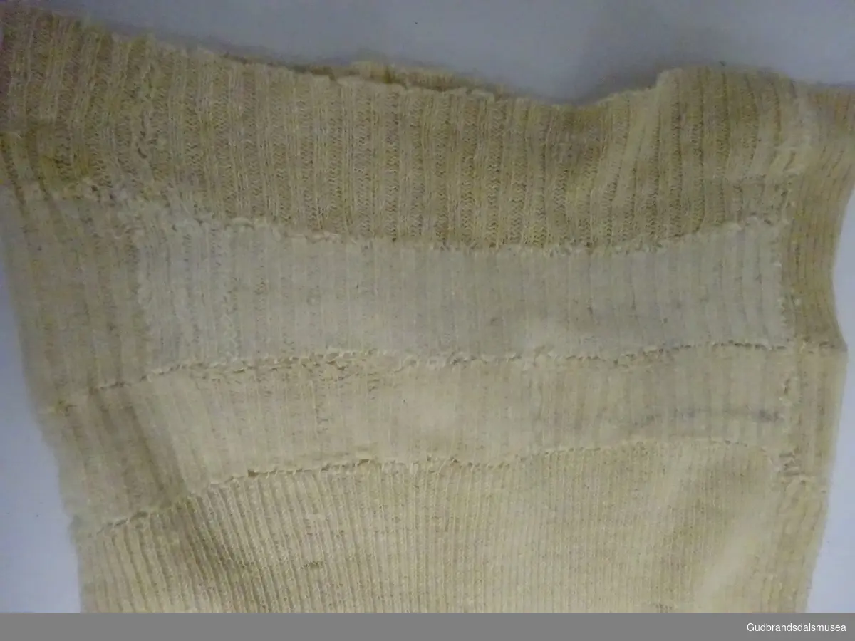Nattskjorte -  strikket. Bøtt sammen av flere plagg for å øke størrelsen. Antagelig brukt deler av sokker. Hjemmespunnet garn.
