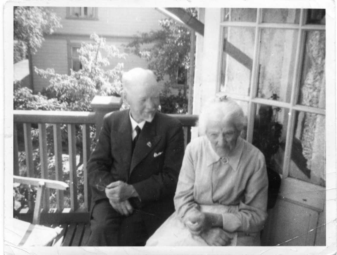 En äldre man och kvinna sitter på en balkong.