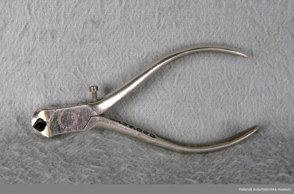 Tång av polerat stål och förkromad. Form som en ändavbitare, men med en skruv. Märkt: "E. Lindström, Eskilstuna, Sweden, -41".
