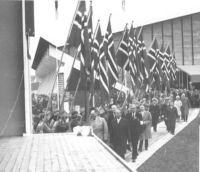 Kong Olav og ordfører Eugen Olsen i spissen for en flaggborg utenfor Sparta Amfi