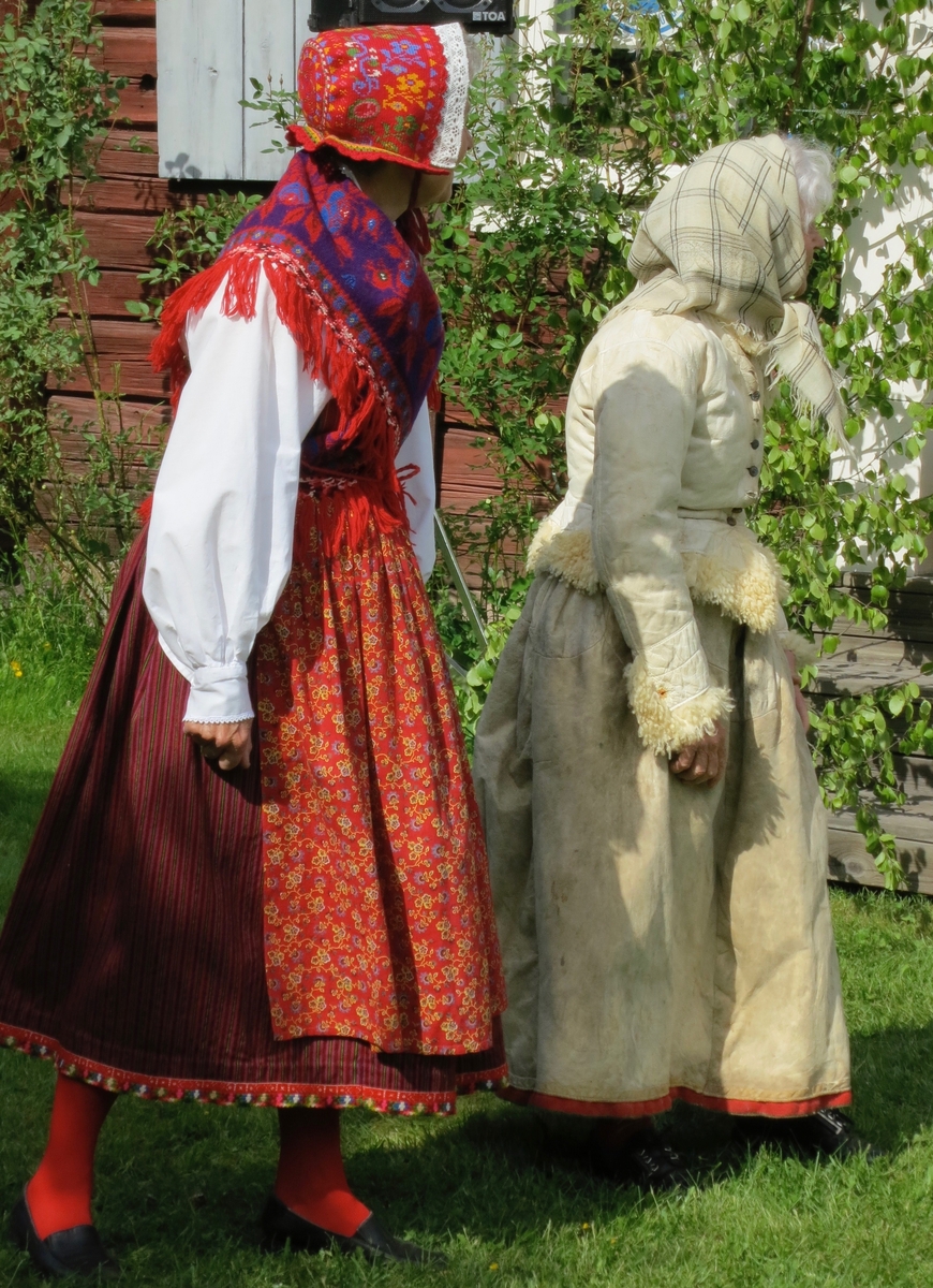 Två nåsdräkter: kvinna finklädd i rödrandig halvyllekjortel om sommaren respektive kvinna vardagsklädd i getskinnskjortel och fårskinnspäls den kalla årstiden.