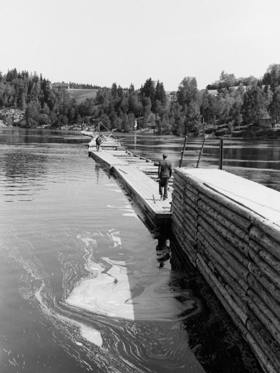 Stivlense med gangbru ved Kykkelsrud i Askim i Østfold, fotofgrafert i 1941. med gangbru. To personer. Gårder bak.