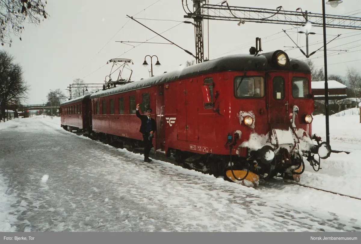 Ombordansvarlig Gunnar Antonsen gir avgangssignal for persontog til Drammen fra Hønefoss på Mjøndalen stasjon. Elektrisk motorvognsett type 68B