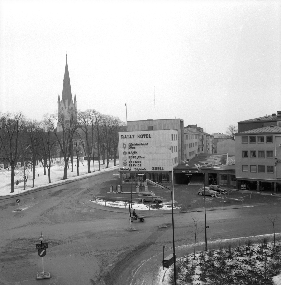 Vägmötet där Barnhemsgatan med flera stråk möter Storgatan i Linköping, kom med ökad bilism vålla tilltagande besvär. Ända in i modern tid var Storgatan och sedermera Drottninggatan stadens stora genomfartsleder, vilket här skapade en alltmer ohållbar trafiksituation. Under 1950-talet sökte man förbättra tillståndet genom att dels flytta Domprostgården för att vidare kunna bredda Storgatan, dels stänga av Nygatan och inte minst anlägga Bredgatan (Drottningsbacken). På det avrivna området där Nygatan tidigare mött korsningen, uppfördes bland annan bebyggelse Rally hotell, invigt 1960 och helt anpassat för bilisters behov.