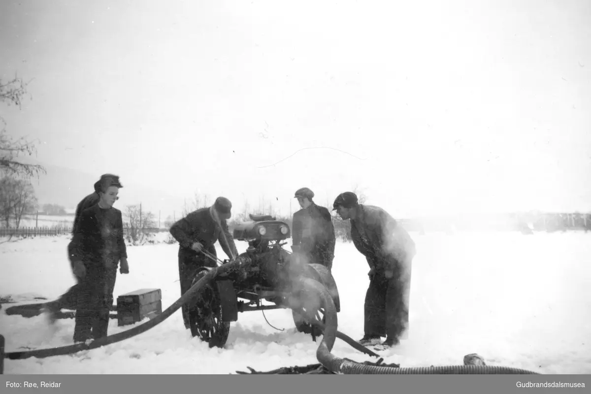 Ei brannsprøyte blir brukt til å legge is på skeisebana på Bersuøya