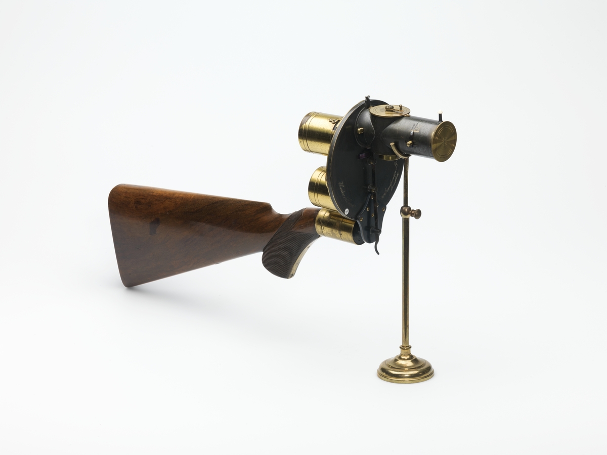 Tørrplatekamera formet som et gevær produsert av Londonbaserte Hunter & Sands i 1883. 
Kameraet holdes og siktes som et gevær. Det er utstyrt med to lagringssylindere for oppbevaring av glassplatene (før og etter eksponering). Platestørrelsen er på 1 ½” i diameter.    
Dette kameraet er et eksempel på et håndholdt kamera. Da tørrplatene kom i 1878, ble eksponeringstidene så korte at man kunne ta bilder med håndholdte kameraer og av ting i bevegelse. Tørrplatene kunne også lagres i magasinet. I dette kameraet er det plass til 18 plater. Firmaet skiftet navn til Sands and Hunter og kom med en ny modell i 1885.