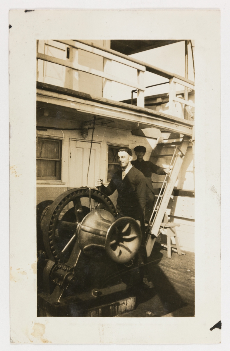 En ung mann styrer en maskin, antageligvis på dampskipet "D/S Christie" mellom Chicago og Lake Michigan, USA. En annen mann følger med i bakgrunnen.