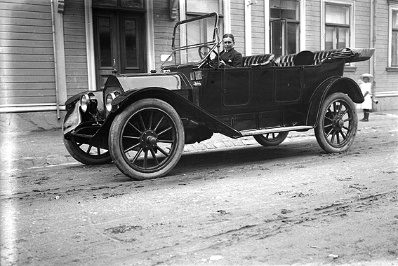 Olle Andersson i en bil av märket  Nyberg 40Hp (Model 4-40) 7-Passenger Touring 1913 
Bilden är tagen utanför Karl Nyströms ateljé på Södra Klaragatan 2.