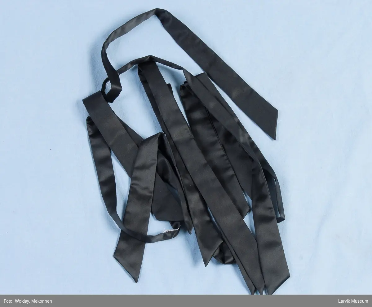 Form: Lange "bånd" som slips men skrå den ene veien i begge ender.
