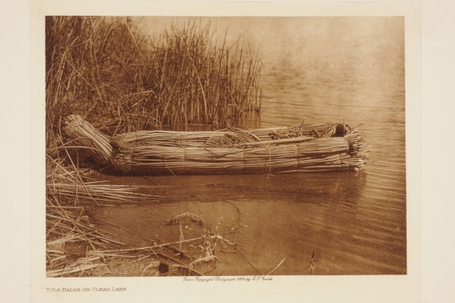 En balsa-båt ligger ved bredden av en innsjø. Det er en tradisjonell båt som den amerikanske urbefolkningen lager av vevd siv.