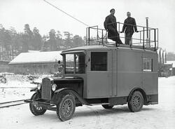 To menn på toppen av en spesiallaget Volvo RV 60 arbeidsbil 