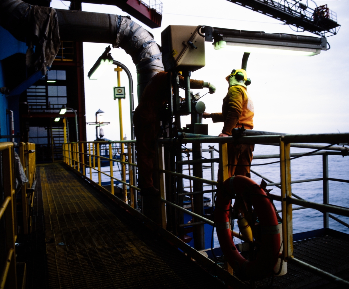 Arbeidere monterer rør på en oljeinstallasjon